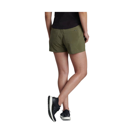 Olive green women’s running shorts shown from the back with rear pocket and black sneakers