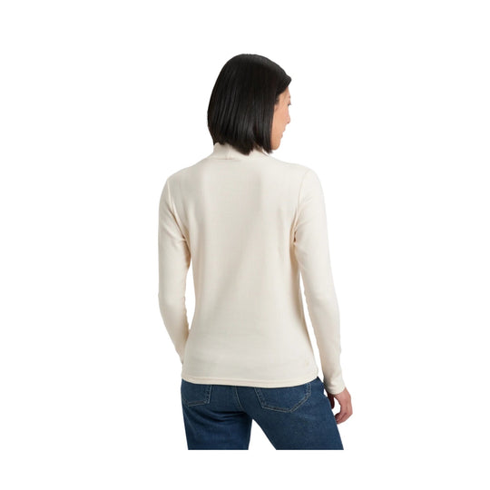 Cream ribbed long-sleeve mock neck top shown from the back, paired with blue jeans