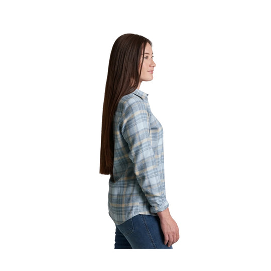 Woman wearing a light blue plaid flannel shirt in side profile