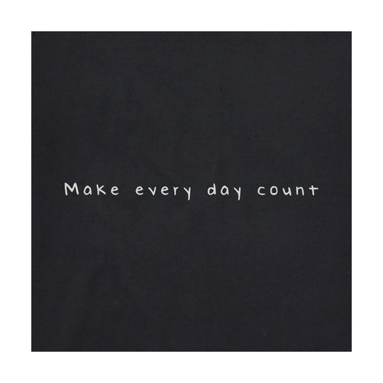 Black graphic tee with handwritten text reading “Make every day count.”
