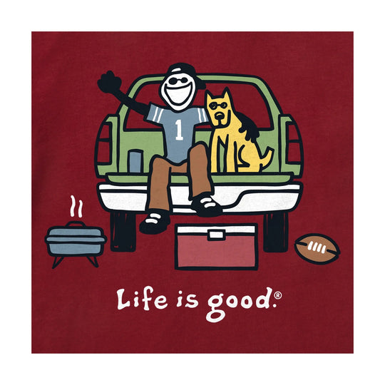 Red graphic T-shirt with a tailgate scene, a smiling person and dog in a pickup truck bed, and the text “Life is good.”
