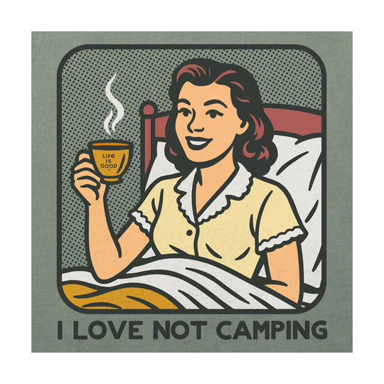 Moss green graphic T-shirt with a retro woman in bed holding a steaming cup and the text “I LOVE NOT CAMPING”