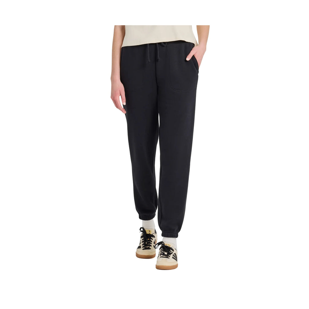 Black fleece jogger pants with drawstring waist and side pockets, worn with sneakers