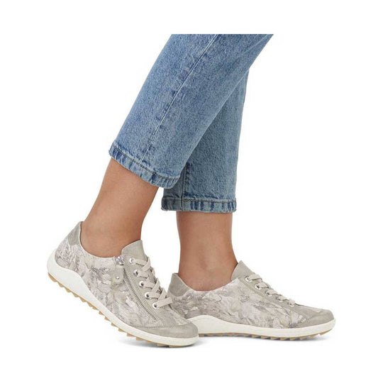 Light beige low-top lace-up sneakers with patterned sides and white soles