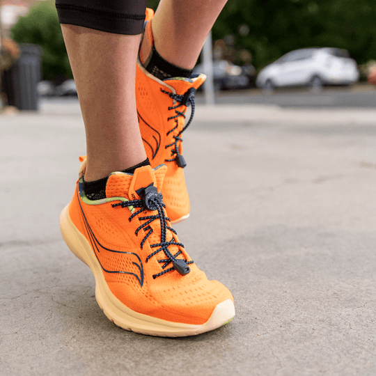 Orange running shoes with black bungee laces and dial adjusters