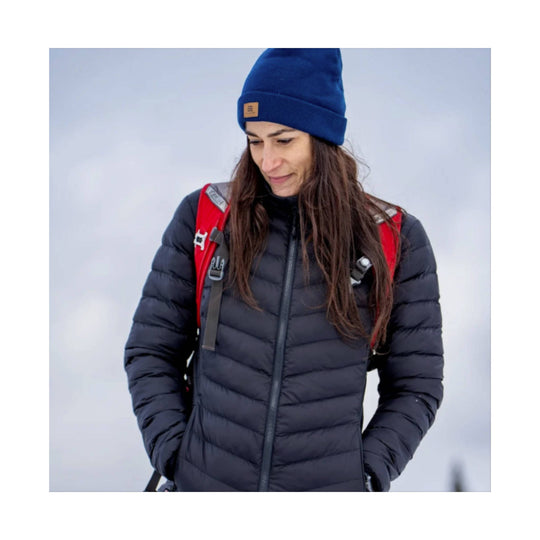 Black quilted puffer jacket worn with red backpack straps and a blue knit beanie