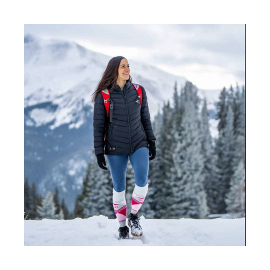 Pink-and-white patterned heated socks worn with winter hiking boots in the snow