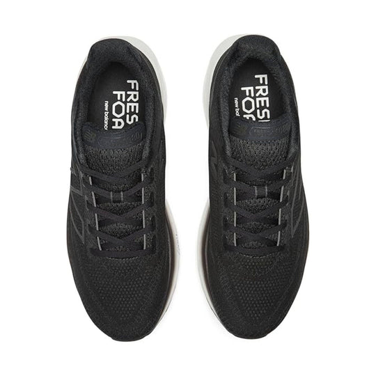 Black low-top running shoes with white soles, top view, showing laces and tongue branding