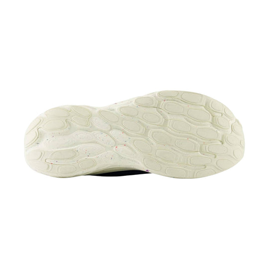 Cream-colored sneaker outsole with oval tread pattern and small colored specks