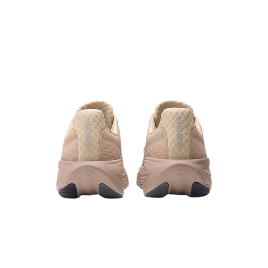 Beige running shoes shown from the back with dark rubber heel accents and vertical 1080 text on the heel tabs