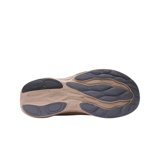 Running shoe outsole in beige and dark gray with oval traction pods