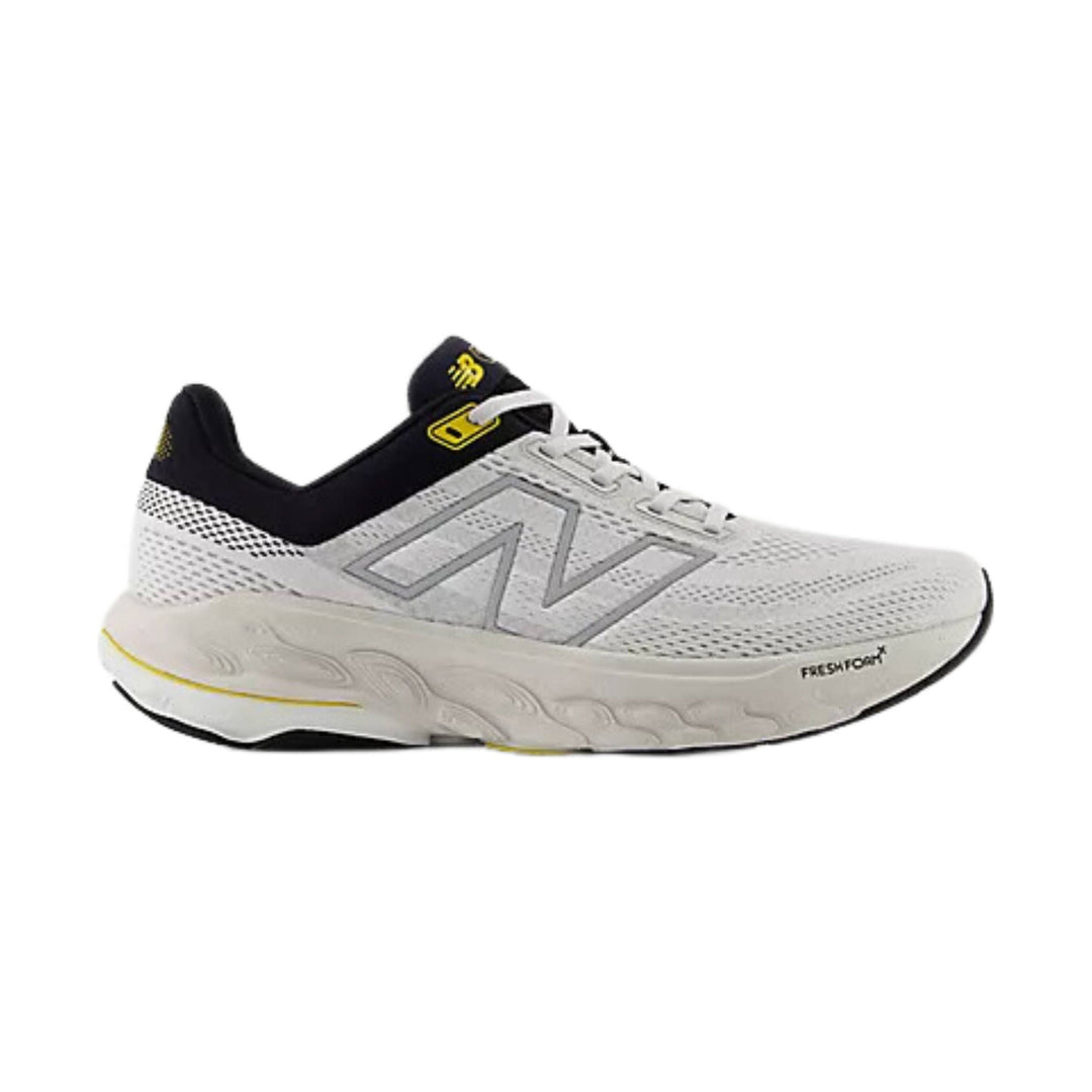 White and black running shoe with gray side logo and yellow heel accents