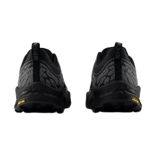 Pair of black trail hiking shoes seen from the back with textured gray uppers and Vibram heel branding.