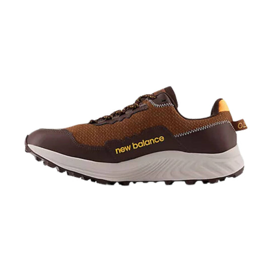 Brown trail running shoe with a white midsole, lugged outsole, and yellow side branding