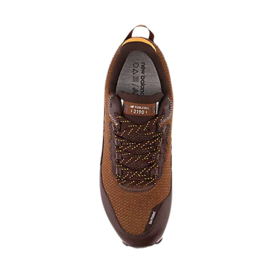 Brown running shoe with mesh upper, speckled laces, and a heel pull tab, shown from above