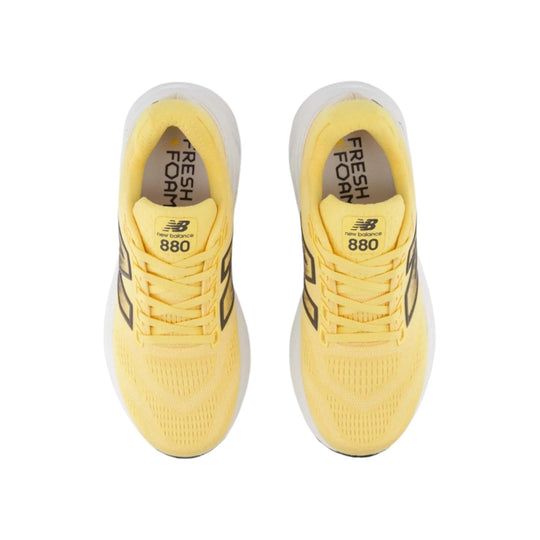 Top view of a pair of yellow running shoes with white midsoles and black side branding