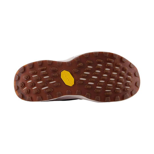 Brown lugged trail shoe outsole with a yellow Vibram logo insert