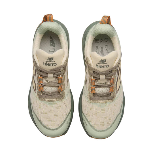 Pair of light beige trail running shoes with olive soles, orange heel pulls, and visible lacing details