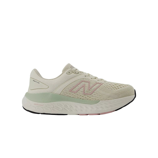 Cream running shoe in side view with pink logo and mint midsole, showing "Made in USA" text