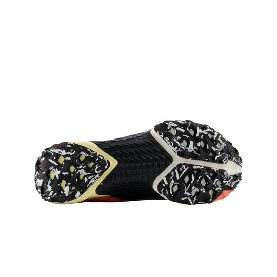 Black trail running shoe outsole with white camouflage traction lugs and yellow accents