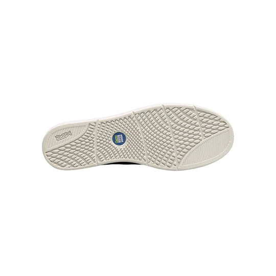 Light beige shoe outsole with textured tread and circular Nunn Bush badge