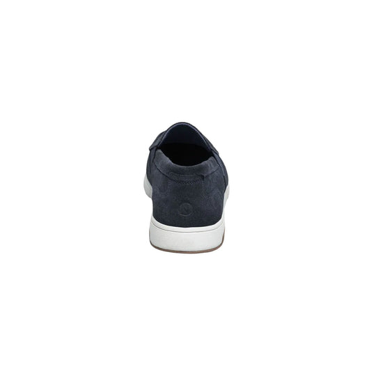 Dark suede slip-on shoe shown from the back with a white sole and brown outsole