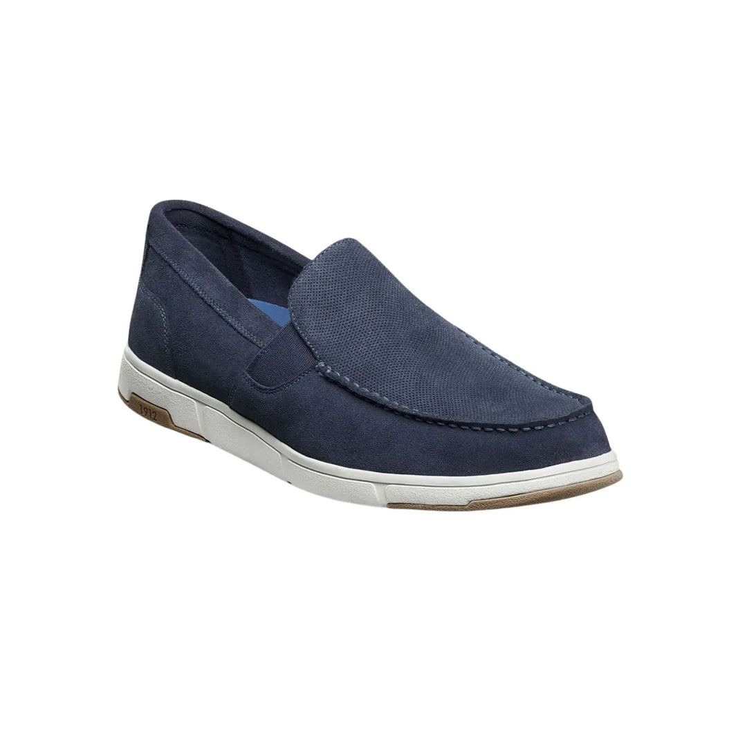 Navy slip-on moc toe shoe with a white rubber sole and tan traction accents