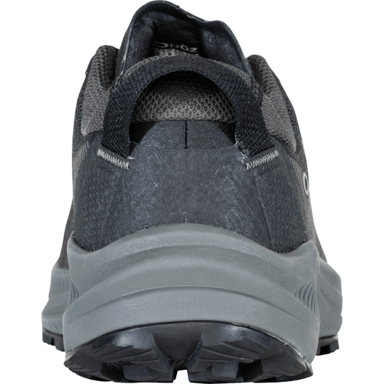 Black low-top hiking shoe viewed from the heel, with gray midsole and lugged outsole