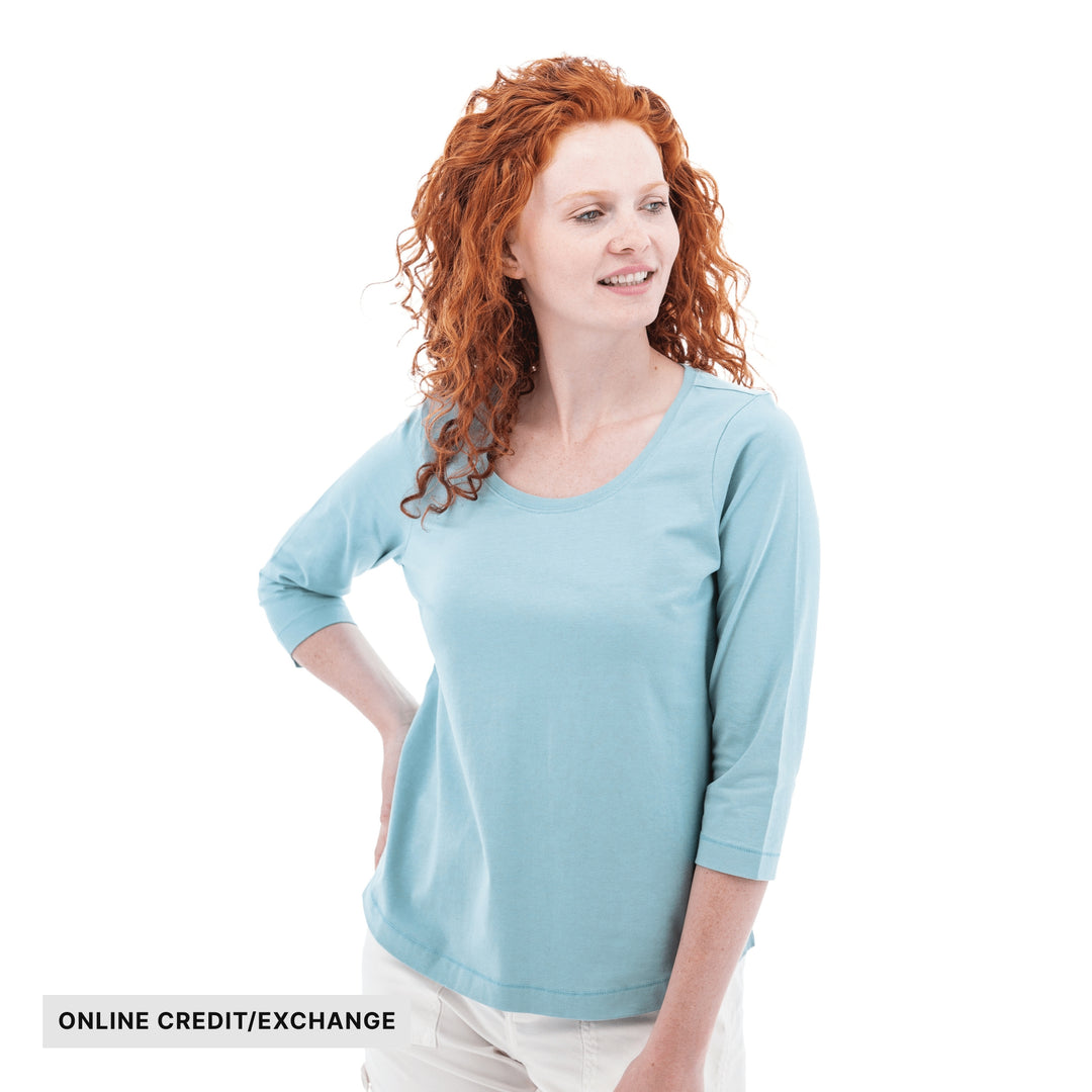 Light blue three-quarter sleeve top on a woman with curly red hair