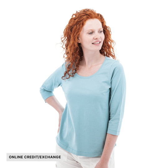Light blue three-quarter sleeve top on a woman with curly red hair