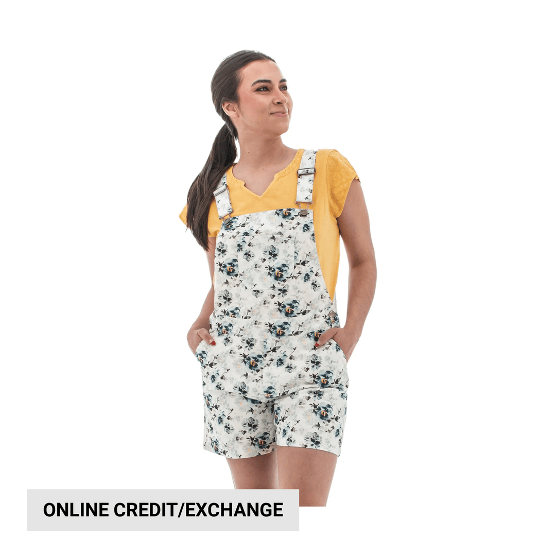 White floral overall shorts over a yellow top with front pockets