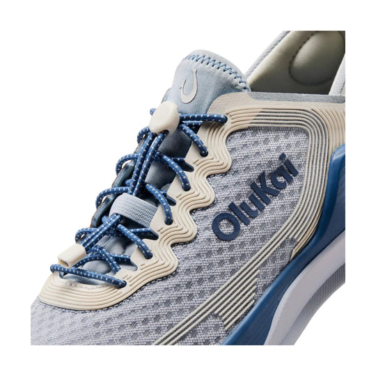 Gray and blue athletic shoe with bungee laces and visible OluKai branding