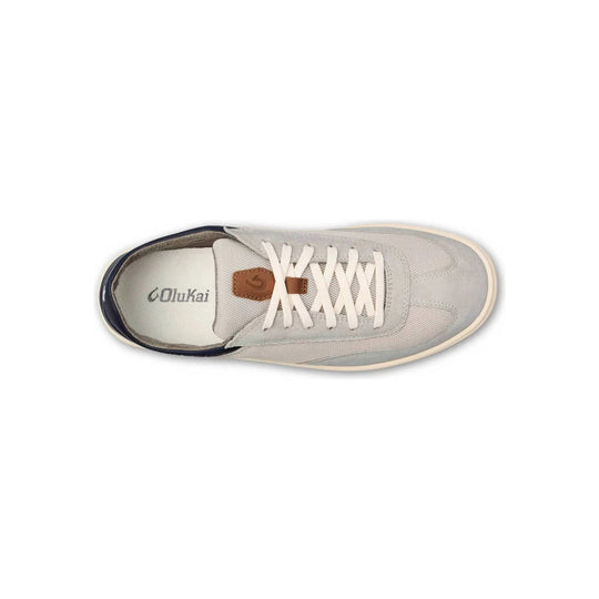 Light gray low-top sneaker with white laces, navy heel trim, and a tan leather tongue tab.