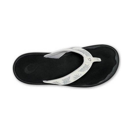 Black and white flip-flop sandal with floral strap pattern, top view
