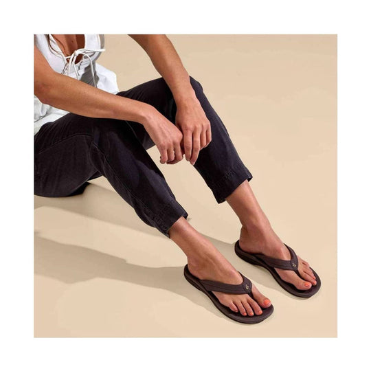 Dark brown thong sandals with rounded footbeds worn with black pants