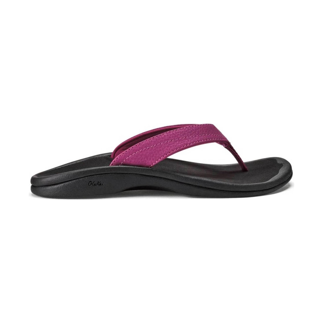 Black thong sandal with a magenta strap and textured footbed, side view