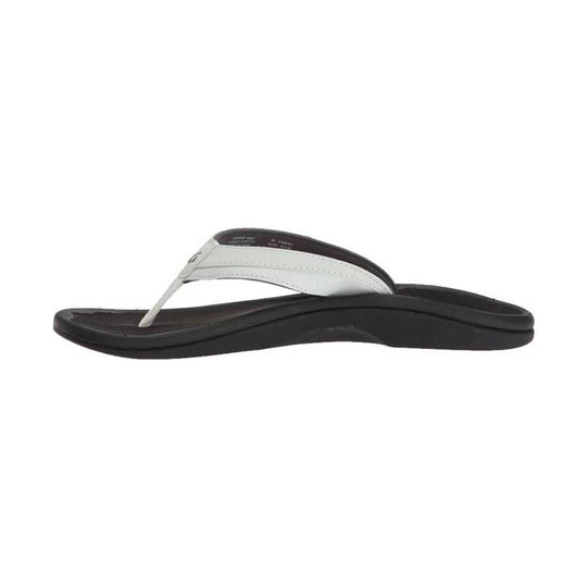 White thong sandal with a black contoured sole, shown in side profile