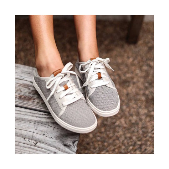 Gray lace-up sneakers with white soles and tan pull tabs