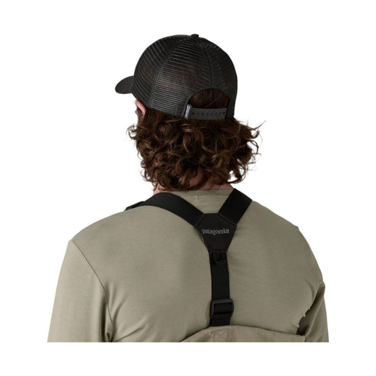 Black mesh trucker hat worn backwards with a curved brim