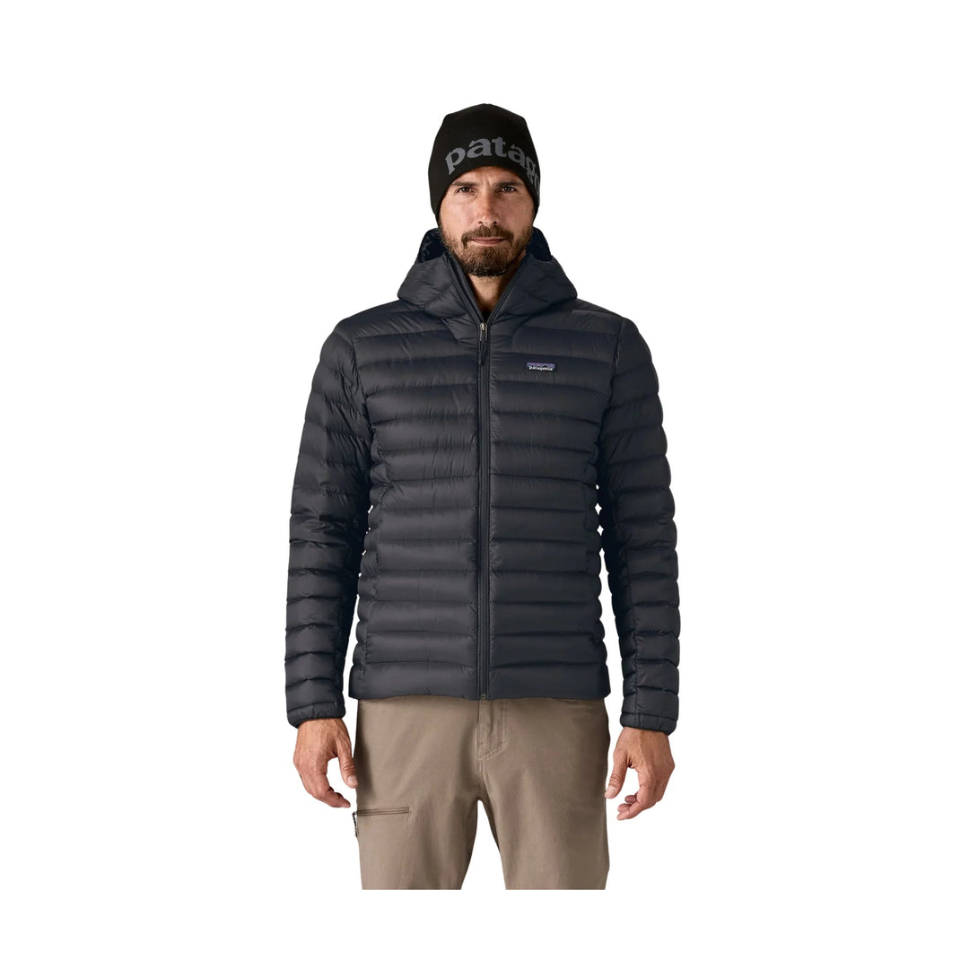 Black hooded puffer jacket with front zipper and Patagonia logo, shown on a model