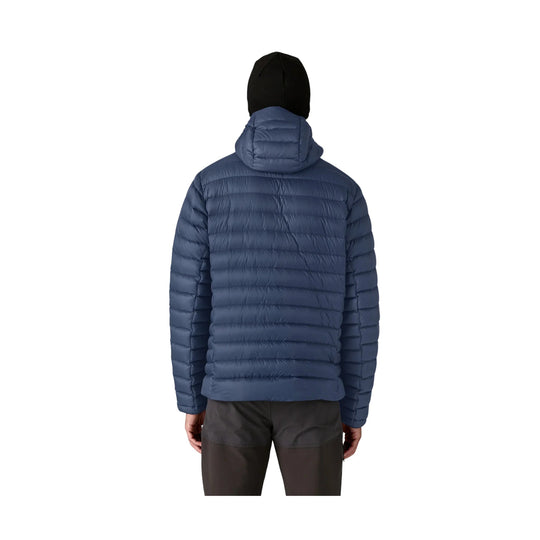 Blue hooded puffer jacket shown from the back with black hood and dark pants
