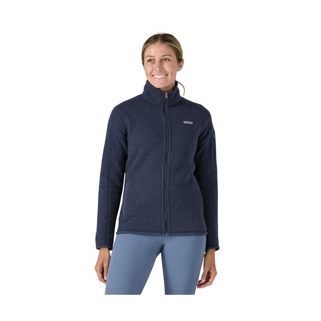 Woman wearing a navy full-zip fleece jacket with a stand collar and chest logo