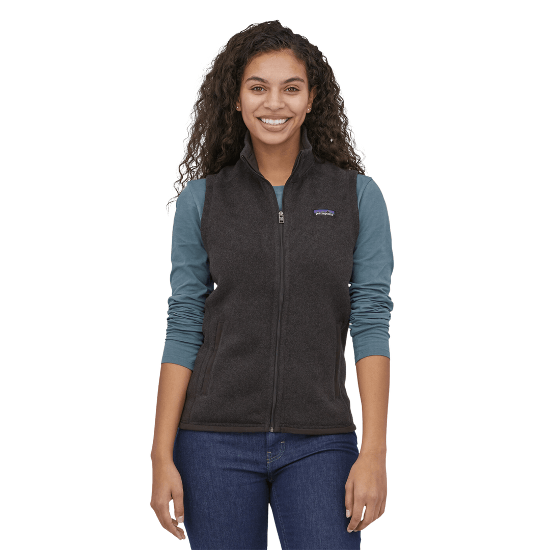 Dark zip-front fleece vest worn over a long-sleeve shirt, with a small chest logo