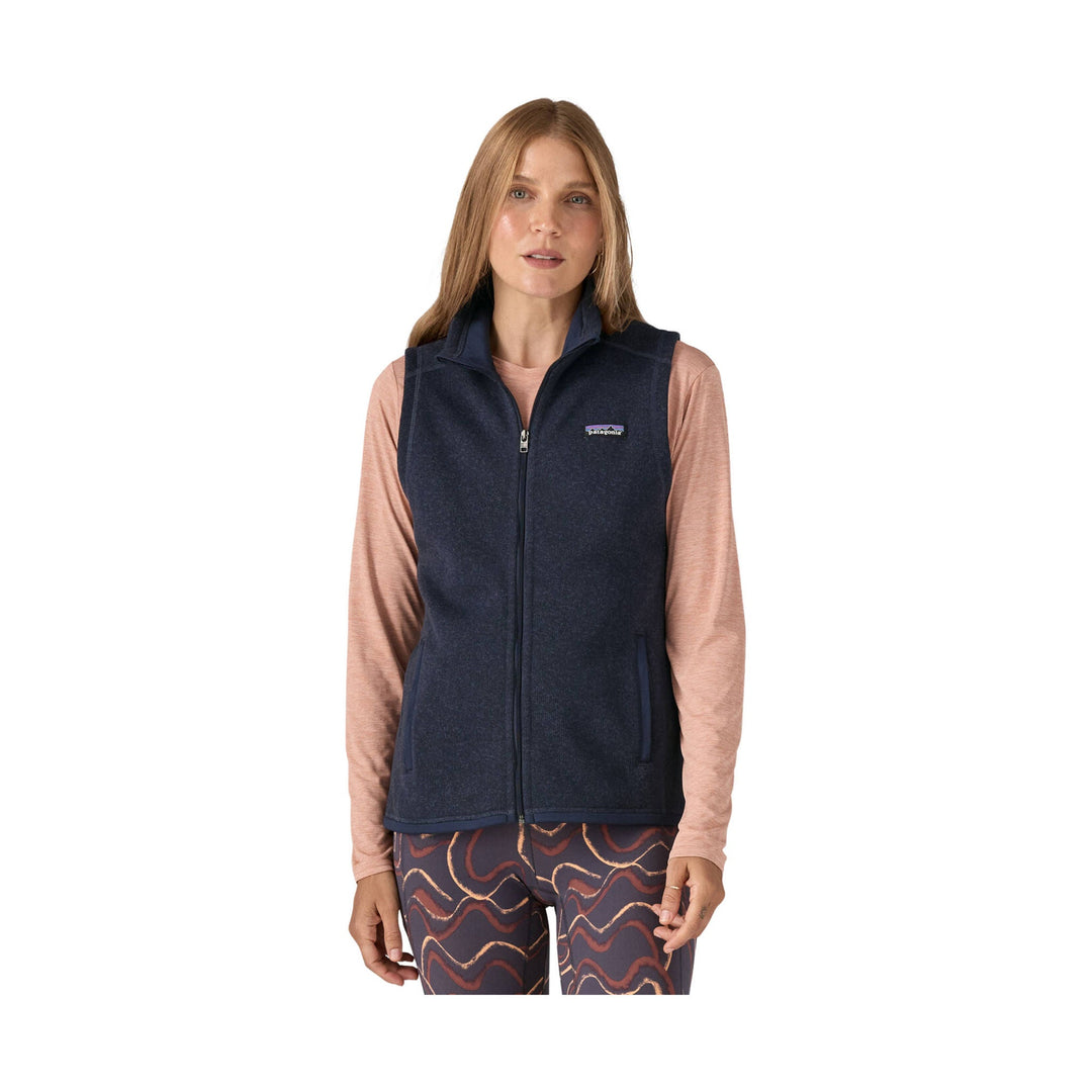 Dark navy fleece vest worn over a long-sleeve shirt, with a front zipper and small chest logo
