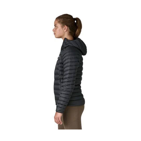 Black quilted hooded puffer jacket shown in side profile on a model