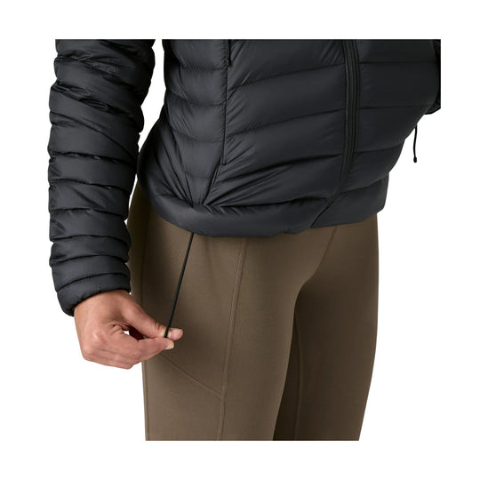 Black quilted puffer jacket over brown leggings, with a zip front and hem drawcord