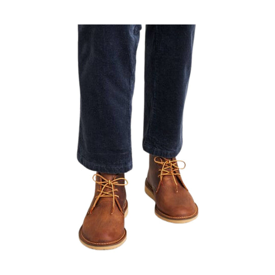 Brown leather chukka boots with tan laces, shown with dark navy corduroy pants