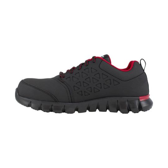 Black low-top work shoe with red trim, triangular side cutouts, and a thick treaded sole.