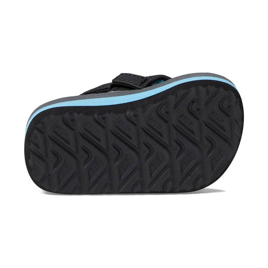Black kids' flip flop seen from below with a light blue side stripe and textured rubber sole
