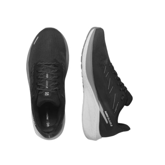 Black low-top running shoes with white midsoles, laced upper, and side branding text.